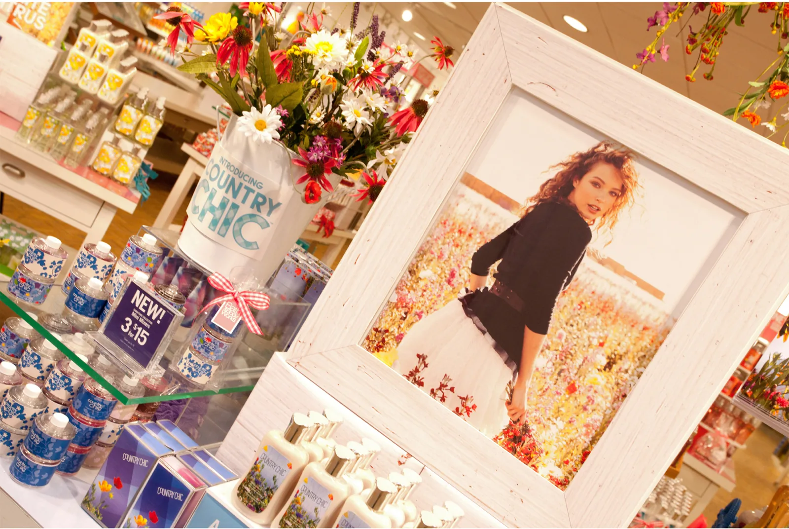 A whitewashed frame on the shop floor holding the campaign image, product stacked around it