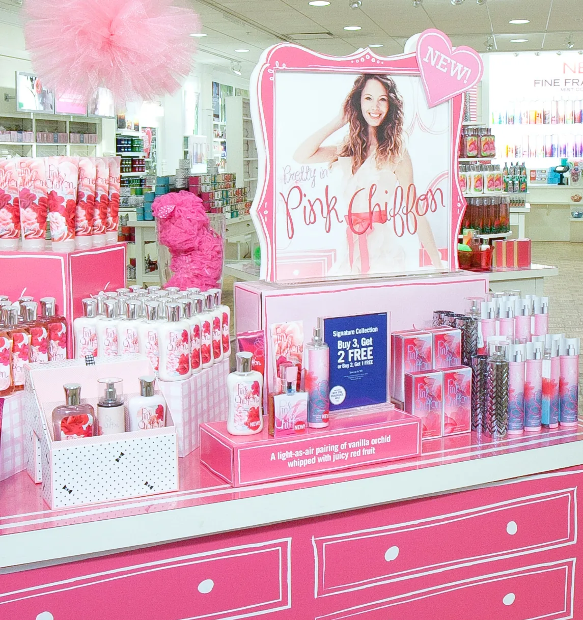 The in-store table, a Pretty in Pink Chiffon header card above stacked lotion and mist