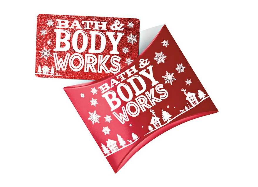 A red pillow box and matching gift card, white village and snowflakes wrapped around both
