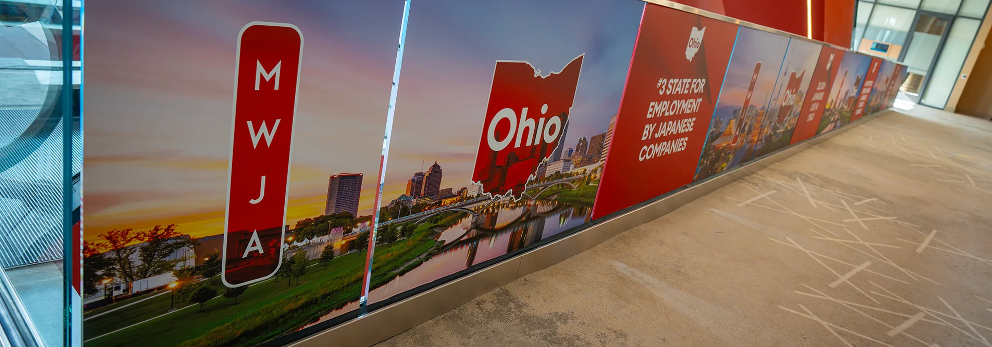 A balcony wrap running the length of a convention centre, Columbus at sunset panelled along it